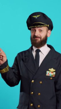 Vertical video: Airline pilot pointing to left or right sides on camera, indicating direction sideways and working in flying industry. Young man dressed as captain having professional occupation