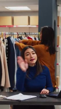 Vertical video: Team of asian people recording promotion video, filming marketing advertisement for teleshopping and business development. Entrepreneur and workers using streaming platform on social