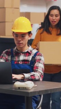 Vertical video: Team of people doing quality control in warehouse, checking stock production before sending retail order packages. Young employees doing teamwork in storage room for management