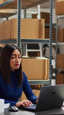 Vertical video: Business owner working on stock logistics with employee in storage room, checking products before supply chain distribution. Team of people doing quality control in warehouse, business