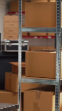 Vertical video: Empty storehouse space filled with multiple goods, storage room with carton packages on shelves. Stock merchandise placed on racks in warehouse, supply chain distribution management.