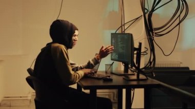 Spy using hacking concept and hacktivism for digital espionage, stealing important government information. Male hacker working with trojan virus to hack firewall, doing cyberattack.