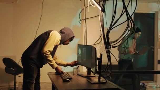 アフリカ系アメリカ人のスパイは 複数のモニターにコンピュータマルウェアを植えるためにドライブを使用して ハードディスクから重要なデータをコピーします 若い大人のハッキングネットワークシステムとセキュリティサーバー 出力ソース — ストック動画