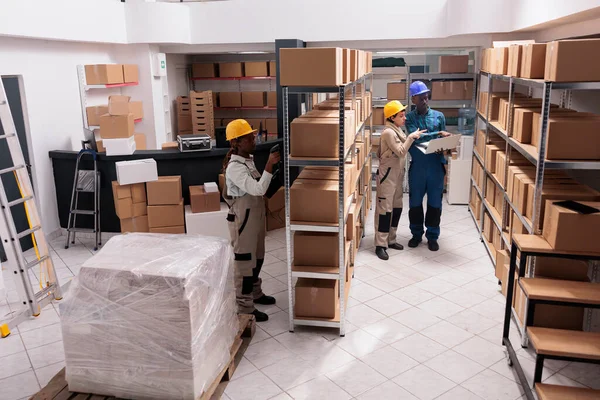Delivery service warehouse managers preparing customer order before dispatching. Mail sorting center diverse operators using barcode scanner and laptop for parcels managing top view