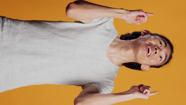 손가락으로 가리키는 스튜디오에서 자신감을 가지고 주황색 방향을 표시하는 미소짓는 — 비디오