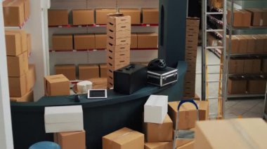 Empty storage room with desk space and shelves or racks, warehouse used for merchandise and shipping goods to customers. Business development to ship products, stock distribution.