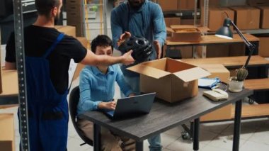 Business owners working on shipping products in warehouse, putting merchandise from shelves in cardboard boxes. Team of partners using goods to work on startup development, supply chain.