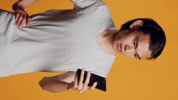 Vertical Video Happy Asian Guy Browsing Internet Mobile Phone Using — Vídeo de stock