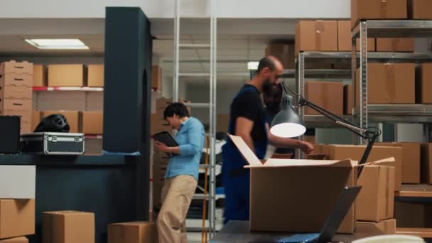 Young Office Employee Arranging Goods Packages Using Laptop Plan Stock — Vídeo de Stock