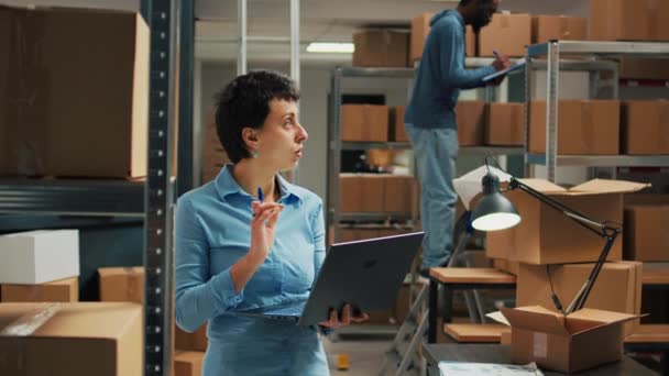 Female Worker Checking Cardboard Packages Storage Room Racks Using Laptop — Stok Video