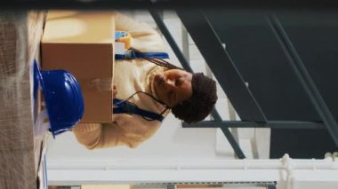 Dikey video: Bir grup işçi depoda mallarla birlikte paketler hazırlıyor, karton kutularda mal paketliyorlar. Çalışanlar paketleri ürün ve kargo ile kontrol ediyorlar, sevkiyat stoku dağıtımı.