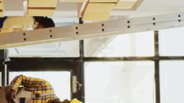 Vertical video: Team of men working on inventory order in warehouse, answering landline phone call to check products for transportation. Young empoyees doing teamwork to prepare merchandise stock.
