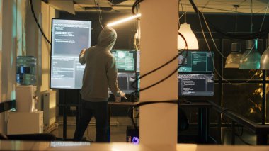 Dangerous spy gaining unauthorized access into computer system, doing phishing for security breach. Person using encryption to convert data and commit cyberbullying. Handheld shot.