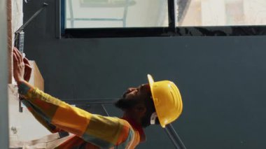 Dikey video: Malzemelerin kalitesini kontrol eden bir grup işçi, malzeme göndermek için raflardan ve depo raflarından karton kutular kullanıyor. İnsanlar envanter ve perakende ürünleri üzerinde çalışıyor. Üçayak atışı.