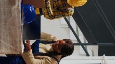 Dikey video: Mutlu bir çalışan grubu gülerek ve kutuları işaretleyerek, paketler ve dağıtım için ürünler hazırlıyor. Depoda çalışan gençler, stok malzemeleri. Üçayak