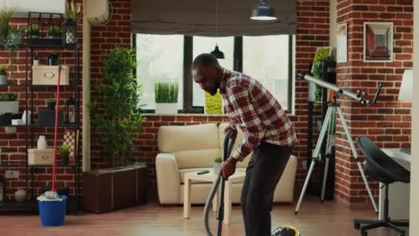 African American Partner Using Vacuum Clean Dust Living Room Doing — Vídeos de Stock