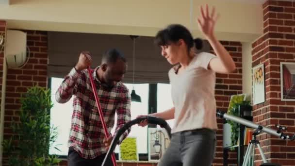 Różnorodni Partnerzy Życiowi Tańczą Śpiewają Urządzeniami Używając Mopa Odkurzacza Mycia — Wideo stockowe