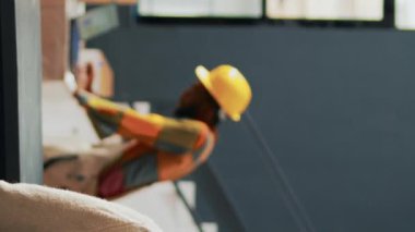 Dikey video: Sipariş yönetimi için dağıtım planlayanlar, mağaza lojistiği için malları kontrol edenler. Kadın ve erkek, depolama odasındaki konteynırları düzenlemek ve ürün kalitesini kontrol etmek hakkında konuşuyorlar.