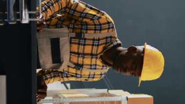 Dikey video: Bir grup işçi depodaki ürünler hakkında konuşuyor, ambalajları ve konteynırları kontrol ediyorlar. Kalite kontrol üzerinde çalışan bir grup insan ve raflarda mallar. El bilgisayarı