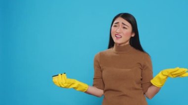 Professional cleaner doing intense cleaning using sponge while ensuring every surface was clean and hygienic. Asian housekepper was skilled in the art of housekeeping, Studio shot