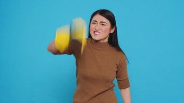 Housekeeper having problem with bad dirt while cleaning customer house using sponge and detergent spray. Maid wore gloves while doing the housework to protect her hands from the harsh detergents.