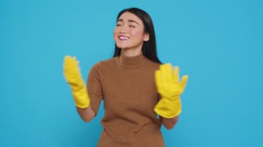 Happy asian maid being happy about finishing house cleaning while enjoying appreciation from her customers. Homekepper doing wonderful job, making sure every inch of the house was spotless.
