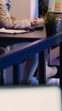 Vertical video: Executive manager feeling frustrated working at night, checking business charts to plan financial graphs report for startup growth. Young adult working under pressure to plan