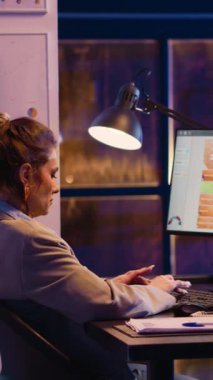 Vertical video: Businesswoman analyzing online report with graphs on computer, planning startup investment and development. Executive agent developing new ideas, typing financial data on research