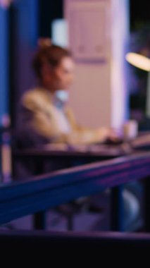 Vertical video: Female advisor reading financial report in startup office looking at economy graphs to increase business profit. Young worker checking diagrams investment plan, working at night