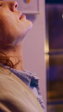 Vertical video: Frustrated employee working under pressure at night, checking financial marketing report in office. Worker feeling stressed and overworked after finishing investment project. Handheld