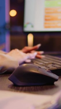 Vertical video: Office worker planning financial investment at night using computer before deadline. Woman checking business statistics at desk, analyzing diagrams to create project. Close up