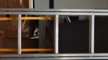Dikey video: Depoda boş ofis alanı, karton kutular, dizüstü bilgisayarlı masa ve perakende satış ürünleri, envanter ve hisse senedi lojistiği üzerinde çalışma. Depoda yığınla mal var, küçük.