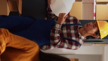 Vertical video: Group of asian people looking at merchandise stock in storage room, checking products before shipment. Depot employees working on quality control for distribution, small business