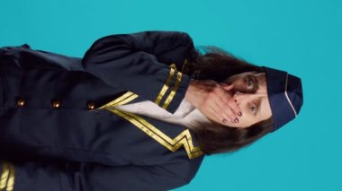 Vertical video: Air hostess feeling tired and yawning in studio, being drained and worn out after commercial flight work. Aircrew member dressed as stewardess being exhausted and falling asleep.