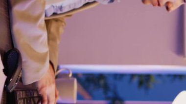 Vertical video: Caucasian businesswwoman planning startup project at desk, using computer to plan research with data diagrams. Female advisor checking analytics and statistics late at night. Handheld