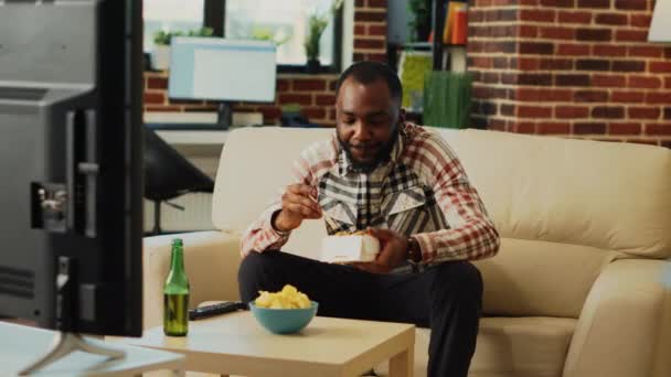 Afro American Folosește Bețișoare Pentru Mânca Tăiței Bea Bere Viziona — Videoclip de stoc