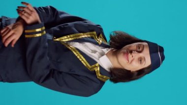 Vertical video: Happy woman airliner working as stewardess, wearing aviation uniform and posing with confidence. Smiling air hostess preparing for commercial flight route, working in flying industry.
