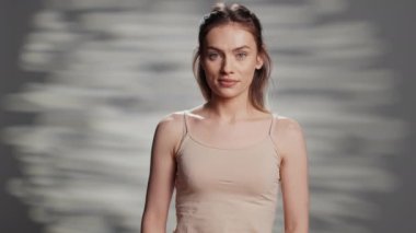 Caucasian model embracing imperfections on camera, feeling happy with luminous glowing look. Gentle smiling girl promoting self confidence with beauty routine and skincare cosmetics.