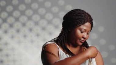 Smiling girl with radiant appearance promoting self love, creating new skincare ad campaign and posing with confidence. Beautiful positive woman expressing self acceptance in studio.