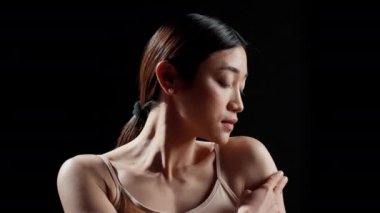 Radiant happy girl applying moisturizer on shoulders, promoting bodycare and body acceptance on camera. Young glowing adult creating ad campaign for cosmetics in skincare routine.