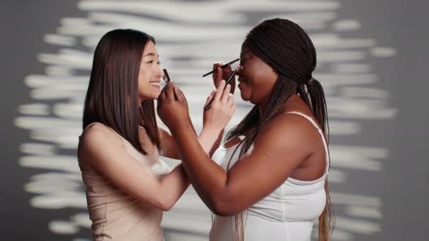 Interracial Beauty Models Giving Each Other Makeovers Using Make Brushes — Stock Video