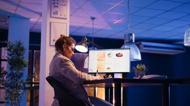 Executive manager analyzing statistics data at desk and using computer to plan financial graphs report. Young worker checking economy diagrams and working on investment. Handheld shot.