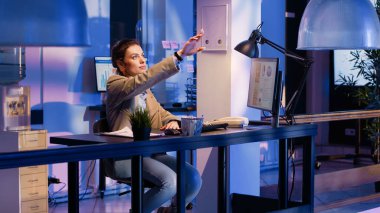 Businesswoman working with hologram in startup office, checking holographic image to research economy diagrams. Executive manager analyzing graphs to create financial corporate report.