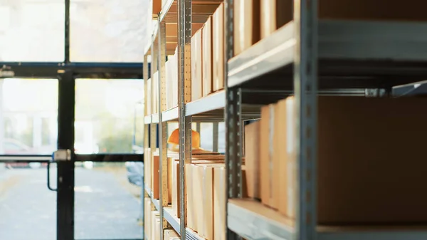Empty storage room filled with cardboard boxes, shelves and racks with merchandise and cargo in warehouse. Distribution goods packed in containers, products shipment in storehouse.