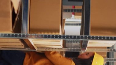 Vertical video: Team of workers planning supply chain management in warehouse, checking supplies packed in boxes. Group of people doing quality control for products and stock, depot production