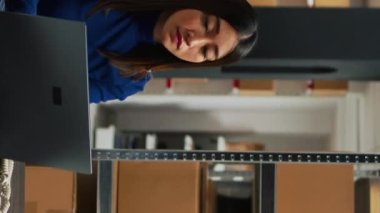 Vertical video: Group of warehouse employees working on distribution, shipping merchandise and doing financial planning on laptop. Man and woman checking quality of products, business management.