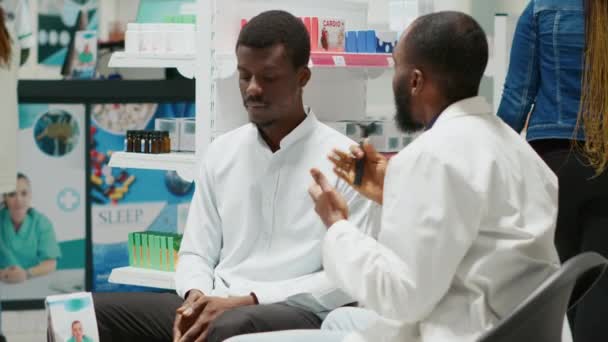 男性の顧客と耳検査を行うために耳鏡を使用して医療専門家 耳鼻咽喉科の相談のための感染症をチェック 若い専門家は病気の人を助け薬を与える 手持ち撮影 — ストック動画