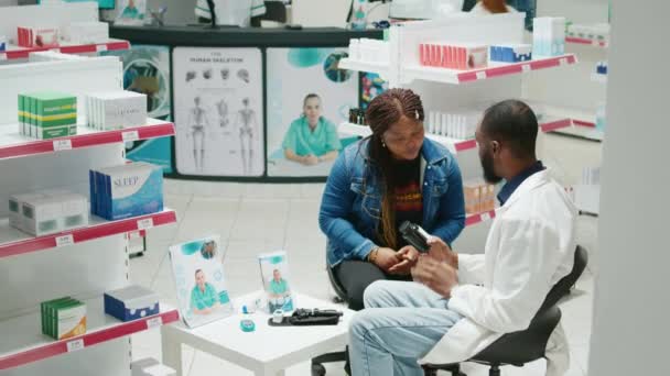 Young Pharmacist Giving Bottle Drugs Customers Explaining Prescription Treatment Disease — Stockvideo