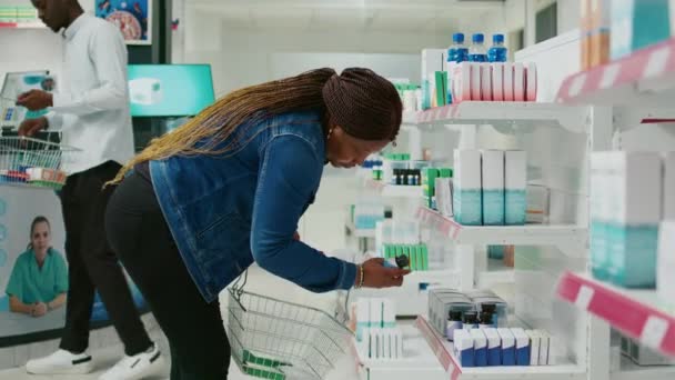 Afroamerykanka Sprawdzająca Produkty Farmaceutyczne Półek Aptecznych Szukająca Lekarstw Witamin Opieki — Wideo stockowe