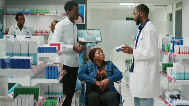 Social Worker Helping Wheelchair User Buy Medicine Pharmacy Receiving Advice — Stockvideo